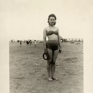 Young woman on the beach in leopardprint two-piece swimsuit