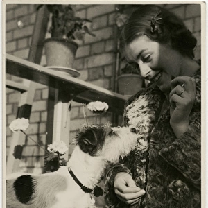 Young woman with a dog in a back garden