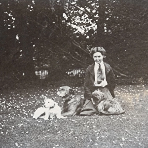 Young woman and three dogs in a garden