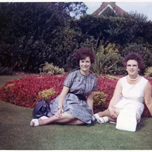 Young woman and her Mother sitting in a formal garden