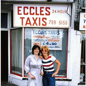 Two young women outside Eccles Taxis