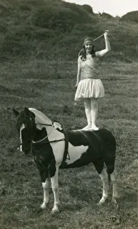 Acrobat of Sangers Circus standing on a horse