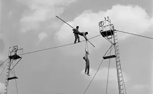 Three acrobats doing balancing act on a high wire