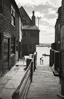 Casually Prints: Adult and child silhouette in water in Yorkshire coastal fishing village Date: 1947 - 1948