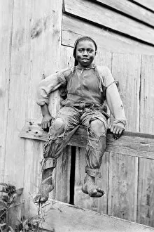 African American Gallery: African-American boy sitting on a fence in America