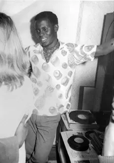 African man in printed shirt talking to a English woman at N