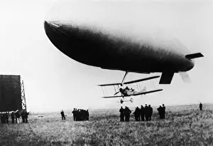 Blimp Prints: Airship with Biplane Fighter Aircraft Hanging Underneath
