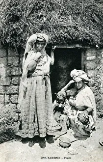 Two Algerian Women (and a young child) outside their home