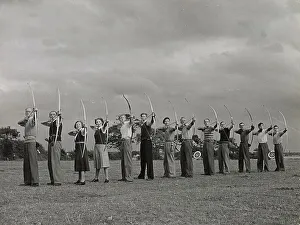 Archery - toxophilites line up, illustrating the correct way to hold the Long Bow, the Wirral, Cheshire, England. Date: 1930s