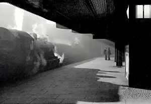 Diagonal Prints: Atmospheric shot in station with strong diagonal light and silhouettes of train workers and train Date: early 1950s