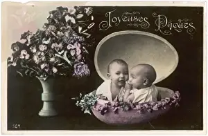 Two babies inside a large Easter egg