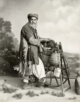 Bearded Egyptian man sharpening knives on grind stone