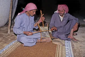Bedouin men in tent in Syrian desert, one plays a rababah Bedouin men in tent in Syrian desert, one plays a rababah