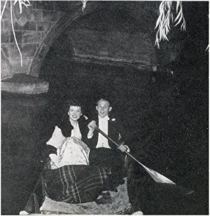 Belinda Stobart and Mr D. K. Wilson out on the river during the May Ball, held by 1st and 3rd Trinity Boat Club at Trinity College. Dancing was on the loggia and in the gardens, while the river was lit by fairy lights. Date: 1956