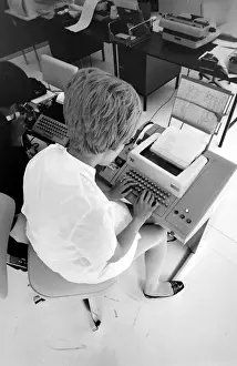 Clerical Prints: Biomedical centre, London -- a woman in an office operates a telex machine