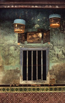 Images Dated 8th August 2019: Two bird cages hang outside a barred house window, Hong Kong