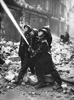 Bombed Gallery: Blitz in London -- firefighters in action with hose, WW2