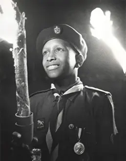 Boy of 3rd Bahamas Scout Troop in torchlight parade
