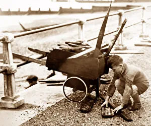 Boy collecting driftwood at seaside, 1930s