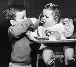 Forcing Prints: Boy feeding baby in a high chair