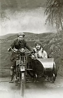 Backdrop Collection: Boy & girl on a 1922 Royal Enfield motorcycle & sidecar in a