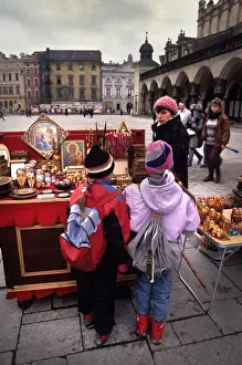 Icons Prints: Boy and girl look at souvenir stall, Main Square, Krakow
