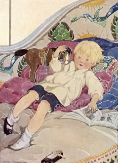 Images Dated 15th March 2012: A boy lying on a bed with a book and a toy horse