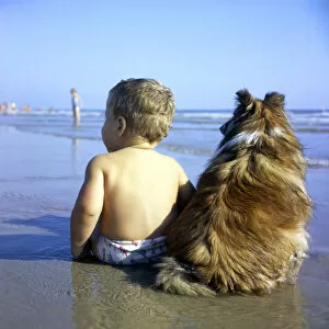 Images Dated 26th January 2017: A boy and his pet dog sitting on a beach