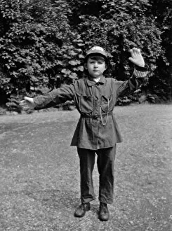 Boy in policemans uniform in a garden