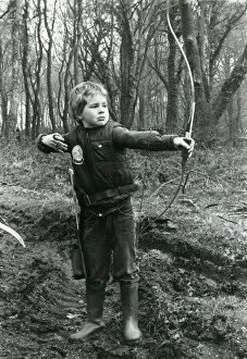 Boy practising archery in a wood
