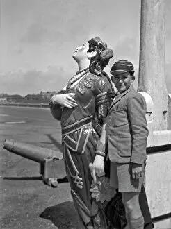 Striped Collection: Boy in school uniform with figurehead at seaside