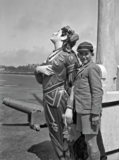 Boy in school uniform with figurehead at seaside
