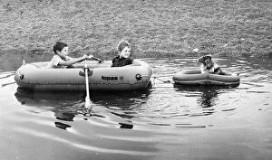 Two boys and a dog in rubber dinghies