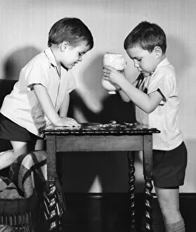 Two boys emptying a piggy bank