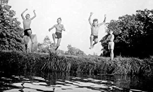 Boys jumping into a stream