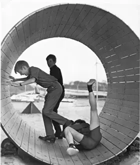 Rotating Prints: Three boys playing inside a large barrel