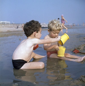 Plastic Collection: Two boys playing in a pool on a sandy beach