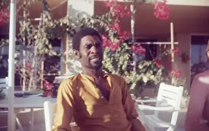 Salalah Prints: British Caribbean man sitting by pool at Holiday Inn Salalah
