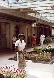 Images Dated 25th July 2016: British Caribbean woman by a floral arrangement, Hong Kong