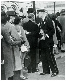 Bus conductor collecting fares from queuers, September 1939