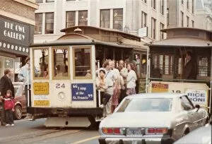 Two cable carts on a busy street in San Francisco