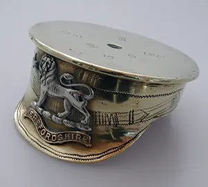 A cap with a Herefordshire Regiment badge