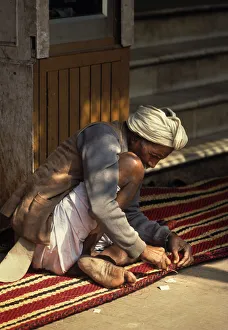 Carpet maker stitches the hem of a striped carpet, Rajasthan Carpet maker stitches the hem of a striped carpet, Rajasthan
