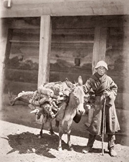 Caucasus Georgia - Georgian man with a heavily laden donkey