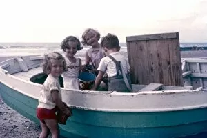1950s Childhood Gallery: Four children on a beach, playing with a boat