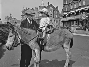 Stirrups Prints: Two children with a donkey at the seaside