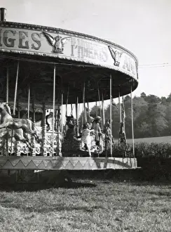 Merry Prints: Children on a merry-go-round at Hascombe fair, Surrey, England. Date: early 1930s