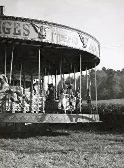 Merry Collection: Children on a merry-go-round at Hascombe fair, Surrey, England. Date: early 1930s