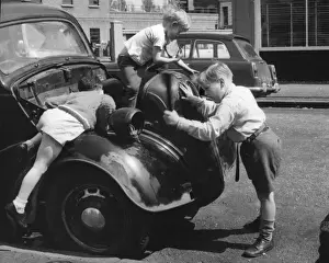 Children playing on a car in a Balham street, SW London