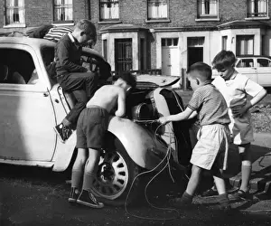Children playing with a car in a Balham street, SW London